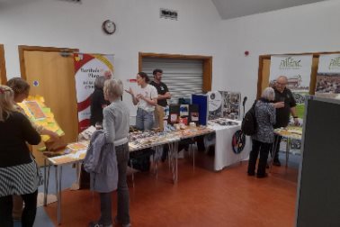 Display areas at APM 2026  - a table with people and leaflets - Photographer Michelle Legg